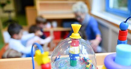 Eine Erzieherin spielt in einer Kita mit Kindern.