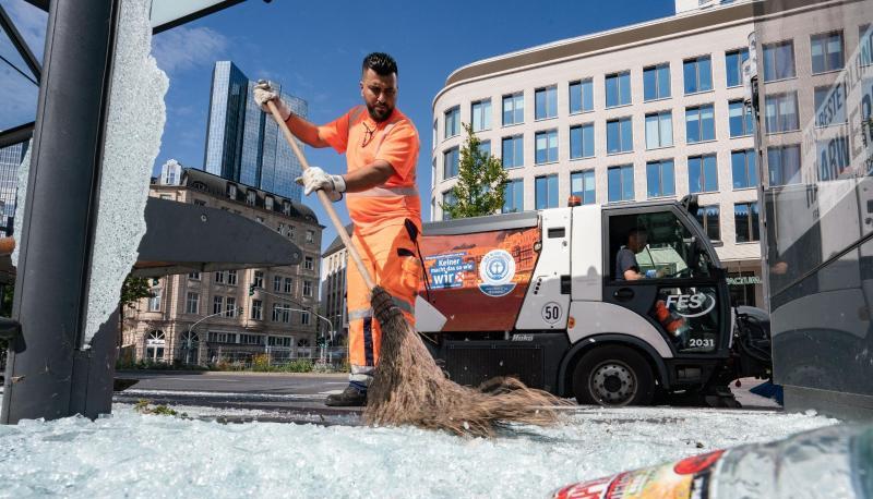Mitarbeiter der Stadtreinigung beseitigen am Morgen vor der Alten Oper Scherben der zertrümmerten Scheiben einer Bushaltestelle. Mitarbeiter der Stadtreinigung beseitigen am Morgen vor der Alten Oper Scherben der zertrümmerten Scheiben einer Bushaltestelle.