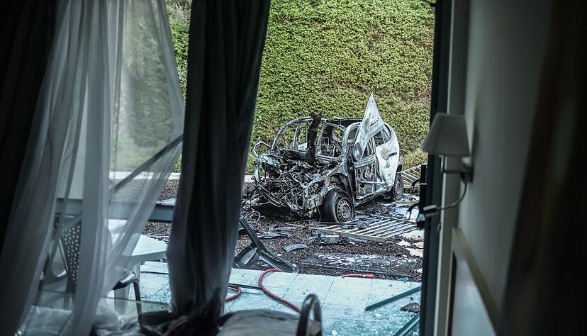 Ein ausgebranntes Auto steht nach einem Raketenangriff der Hamas vor einem beschädigten Haus in Ashkelon im Süden Israels.