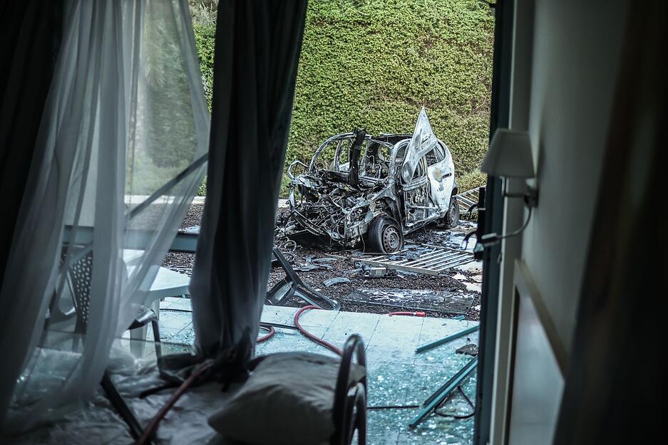 Ein ausgebranntes Auto steht nach einem Raketenangriff der Hamas vor einem beschädigten Haus in Ashkelon im Süden Israels.