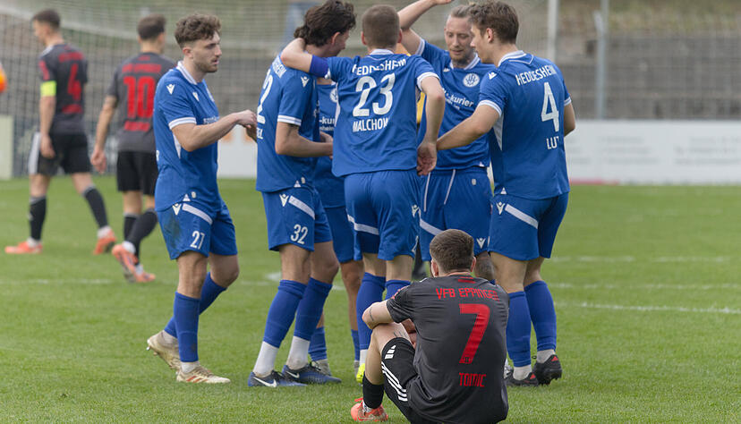Der Eppinger Dejan Tomic (vorne) sitzt nach Abpfiff entt&auml;uscht auf dem Rasen, w&auml;hrend die Heddesheimer feiern.