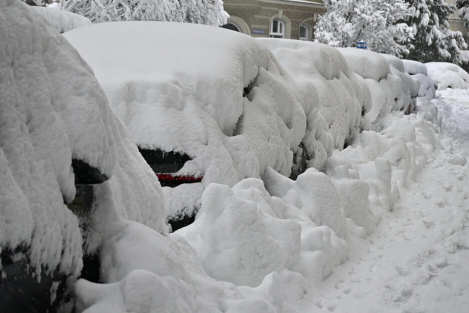 Eine dicke Schneeschicht liegt auf parkenden Autos.