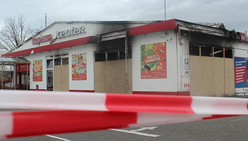 Die Scheiben des Topkar-Markts in der Heilbronner Schaeuffelenstraße sind nach dem verheerenden Brand verbrettert. Die Polizei hat das Gelände abgesperrt.
