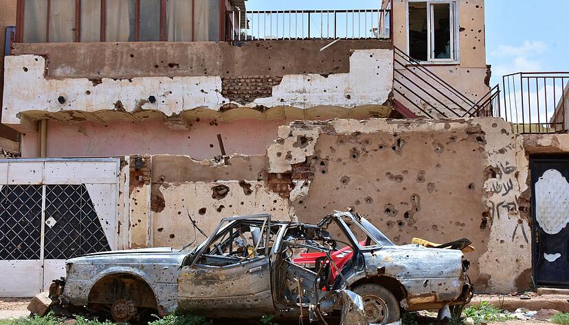 Ein zerst&ouml;rtes Auto steht im sudanesischen Omdurman vor einem Haus voller Einsch&uuml;sse. (Archivbild)