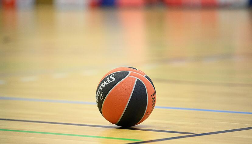 Ein Ball liegt auf einem Basketball-Spielfeld.