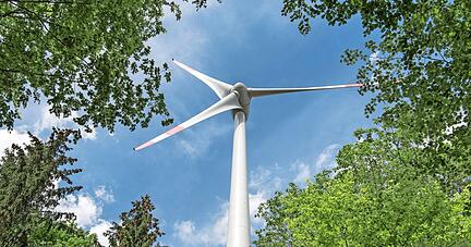 Bislang nicht gänzlich unumstritten, aber gerade in waldreichen Gebieten für die Energiewende nötig: ein Ökostrom-Generator umsäumt von Bäumen.
Foto: Archiv/Weigel