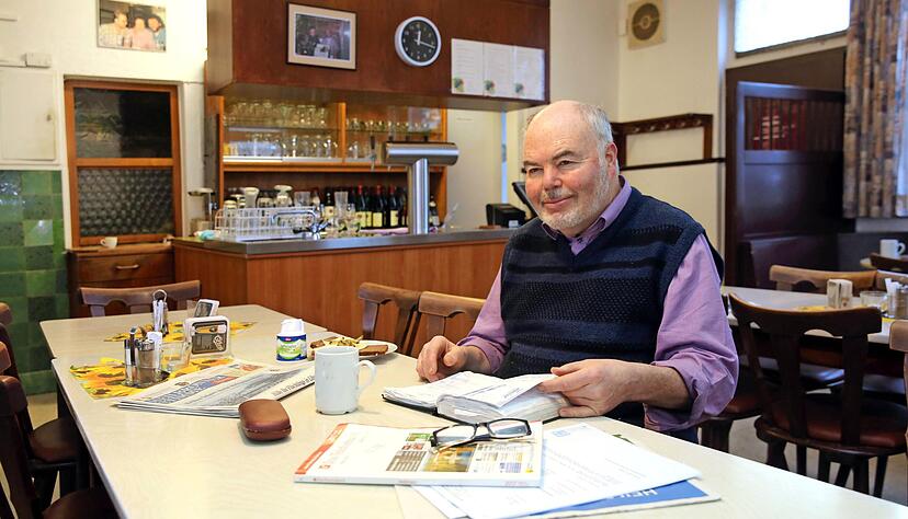 Ein Becher Kaffee, eine Scheibe Brot und das dicke Reservierungsbuch immer griffbereit: Sein Frühstück mitten im Lokal, ein bisschen Zeit nur für sich, das genießt Lothar Hesser. Foto: Andreas Veigel