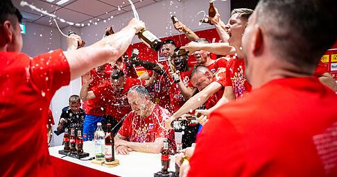 Heidenheims Trainer Frank Schmidt wird von seinen Spieler mit einer Bierdusche überrascht.