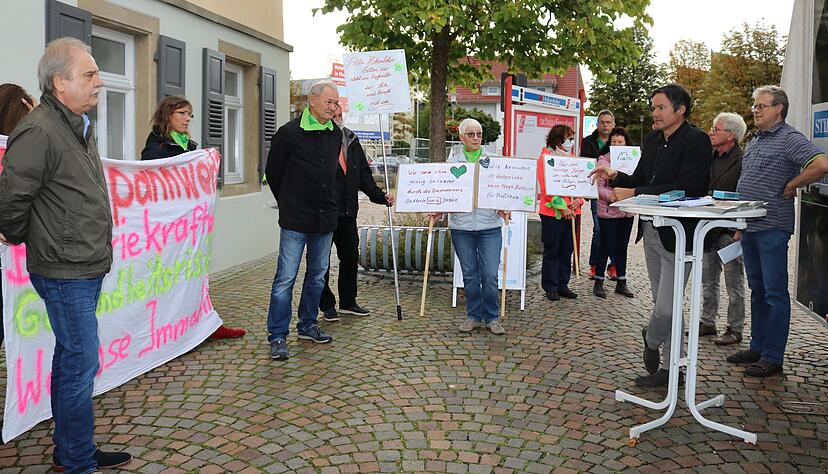 Debatte um das Pilotprojekt: Mit Schildern und Transparenten machen die Mitglieder der Bürgerinitiative "Ein Herz für Hohenlohe" auf ihre Anliegen aufmerksam. HZ-Redaktionsleiter Ralf Reichert (am Stehtisch) erklärt seine Position.
Foto: Nick Debatte um das Pilotprojekt: Mit Schildern und Transparenten machen die Mitglieder der Bürgerinitiative "Ein Herz für Hohenlohe" auf ihre Anliegen aufmerksam. HZ-Redaktionsleiter Ralf Reichert (am Stehtisch) erklärt seine Position.
Foto: Nick