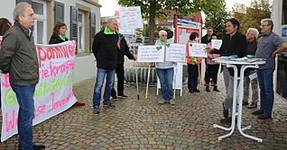 Debatte um das Pilotprojekt: Mit Schildern und Transparenten machen die Mitglieder der Bürgerinitiative "Ein Herz für Hohenlohe" auf ihre Anliegen aufmerksam. HZ-Redaktionsleiter Ralf Reichert (am Stehtisch) erklärt seine Position.
Foto: Nick