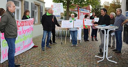 Debatte um das Pilotprojekt: Mit Schildern und Transparenten machen die Mitglieder der Bürgerinitiative "Ein Herz für Hohenlohe" auf ihre Anliegen aufmerksam. HZ-Redaktionsleiter Ralf Reichert (am Stehtisch) erklärt seine Position.
Foto: Nick