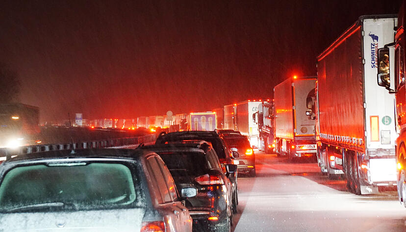 Nach starkem Schneefall stehen Autos und Lastwagen auf der mit Schnee bedeckten Autobahn A8. Die A8 zwischen Aichelberg und Hohenstadt war zwischenzeitlich voll gesperrt. Foto: Sdmg / Kohls/SDMG/dpa