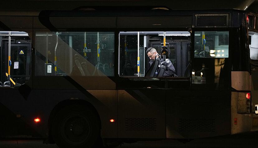 Ein Polizeibeamter inspiziert einen Bus.
