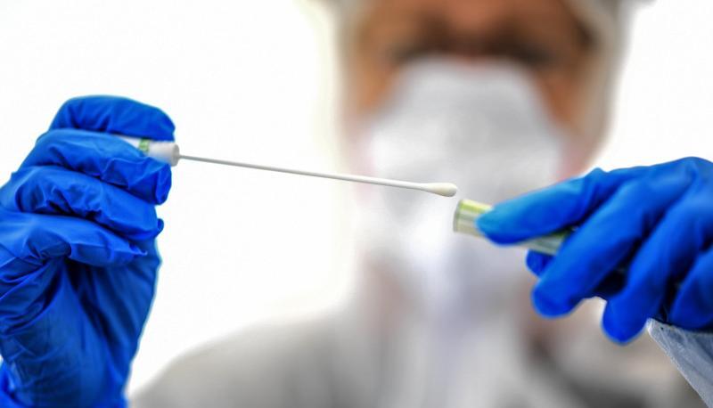 Ein Abstrichst&auml;bchen wird in einer ambulanten Corona-Test-Einrichtung gehalten.