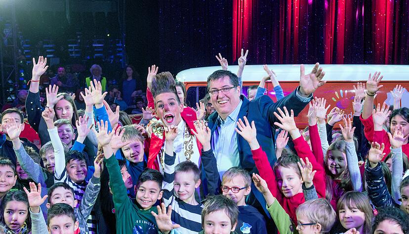 Kinder und Organisator Andreas Fischer formen mit ihren H&auml;nden die "Miteinander"-Hand, das Zeichen des Vereins.

Fotos: Mario ?Berger