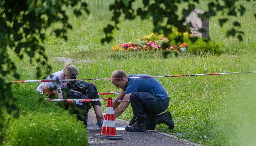 Mitarbeiter der Spurensicherung arbeiten am Tatort auf dem Friedhof in Altbach.