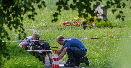 Mitarbeiter der Spurensicherung arbeiten am Tatort auf dem Friedhof in Altbach.