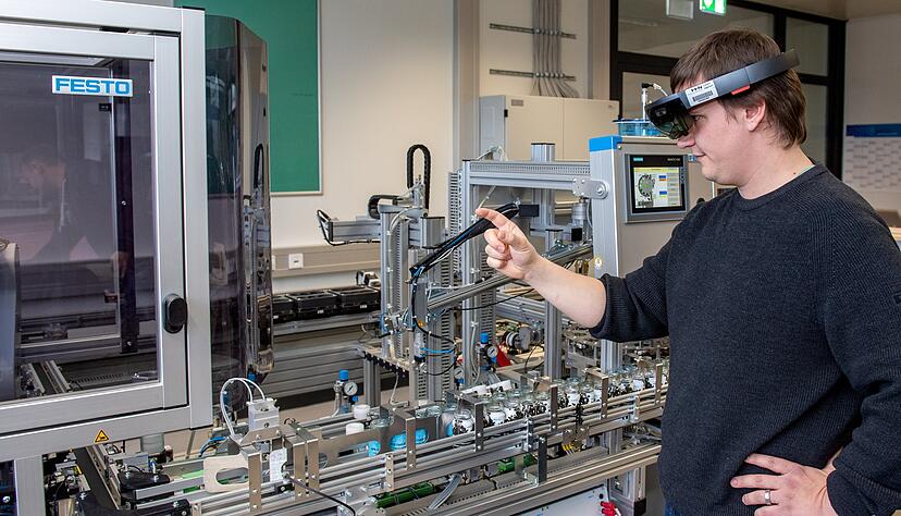 An dieser Abfüllanlage wird deutlich, was Industrie 4.0 bedeutet. Statt über sichtbare Schalter wird sie über virtuelle Bedienelemente gesteuert. Mechatroniker Benedict Bauer kann sie in der VR-Brille sehen. Foto: Mario Berger An dieser Abfüllanlage wird deutlich, was Industrie 4.0 bedeutet. Statt über sichtbare Schalter wird sie über virtuelle Bedienelemente gesteuert. Mechatroniker Benedict Bauer kann sie in der VR-Brille sehen. Foto: Mario Berger
