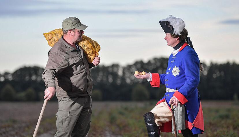 Nachgestellte Szene: Ein Mann im Kost&uuml;m als &laquo;Alter Fritz&raquo; spricht mit einem Kartoffelbauern. (Foto von 2019)