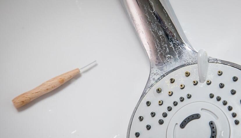 Kalk verstopft die feinen D&uuml;sen am Duschkopf und l&auml;sst den Wasserstrahl schw&auml;cher werden.