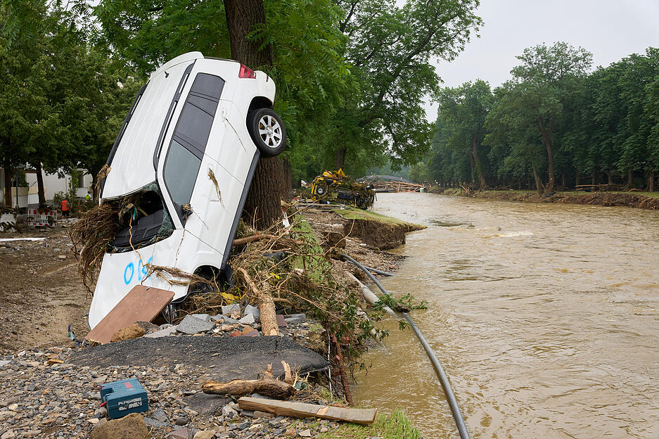 Ein Autowrack lehnt an einen Baum. In den vom Unwetter betroffenen Gebieten beginnen die Aufräumarbeiten. +++ dpa-Bildfunk +++ Ein Autowrack lehnt an einen Baum. In den vom Unwetter betroffenen Gebieten beginnen die Aufräumarbeiten. +++ dpa-Bildfunk +++