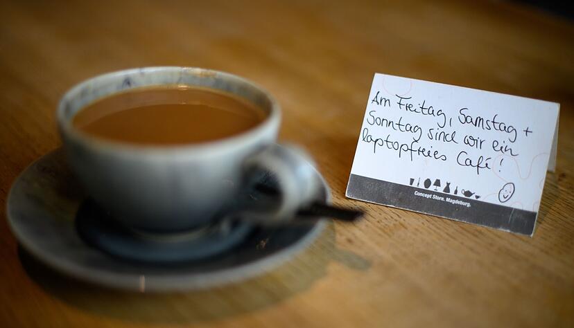 Schilder auf den Tischen weisen im Cafe &laquo;Thies Wohnen und Leben&raquo; in Magdeburg auf die laptopfreien Tage hin.
