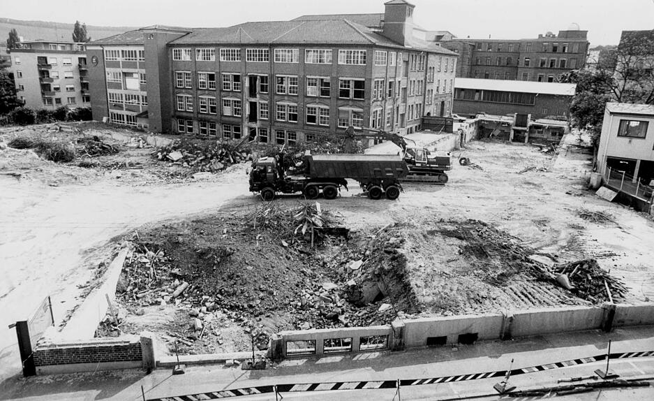 August 1991: Die Briefh&uuml;llenfabrik verlegt ihren Standort von der Heilbronner Innenstadt in das Gewerbegebiet B&ouml;llinger H&ouml;fe. Die Werkshallen der Firma Kuvert-Mayer werden f&uuml;r den Bau des neuen Bismarckparks abgerissen. Im Hintergrund rechts ist das Robert-Mayer-Gymnasium zu sehen.