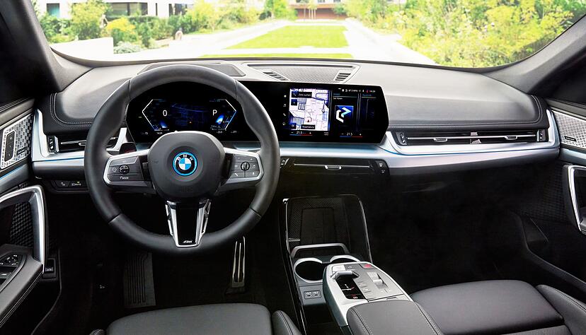Das Cockpit im BMW iX1 erinnert ein bisschen an den gro&szlig;en Bruder iX. Die klassischen Instrumente wurden durch ein leicht gebogenes Display und einen gro&szlig;en Touchscreen ersetzt.