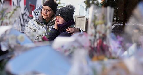 Menschen trauern hinter Blumen und Briefen in der Nähe der abgeriegelten Le Constellation Bar, wo ein verheerender Brand Tote und Verletzte während der Neujahrsfeierlichkeiten in Crans-Montana, Schweizer Alpen, forderte. Menschen trauern hinter Blumen und Briefen in der Nähe der abgeriegelten Le Constellation Bar, wo ein verheerender Brand Tote und Verletzte während der Neujahrsfeierlichkeiten in Crans-Montana, Schweizer Alpen, forderte.
