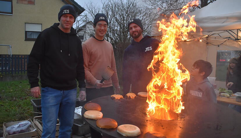 Feuer und Flamme sind die Mitglieder der  freikirchlichen Jes-Gemeinde aus Schwabbach: Sie grillen am offenen Feuer Burger.