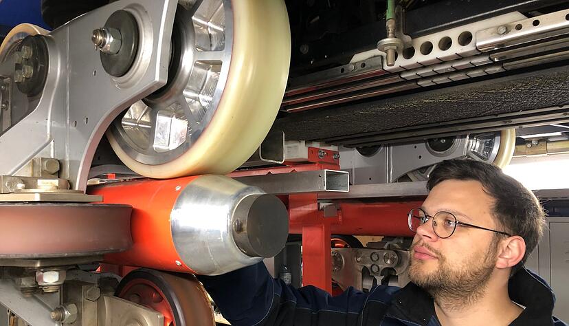 Ein leitender Mitarbeiter des Europa-Parks begutachtet R&auml;der eines Achterbahnzugs.