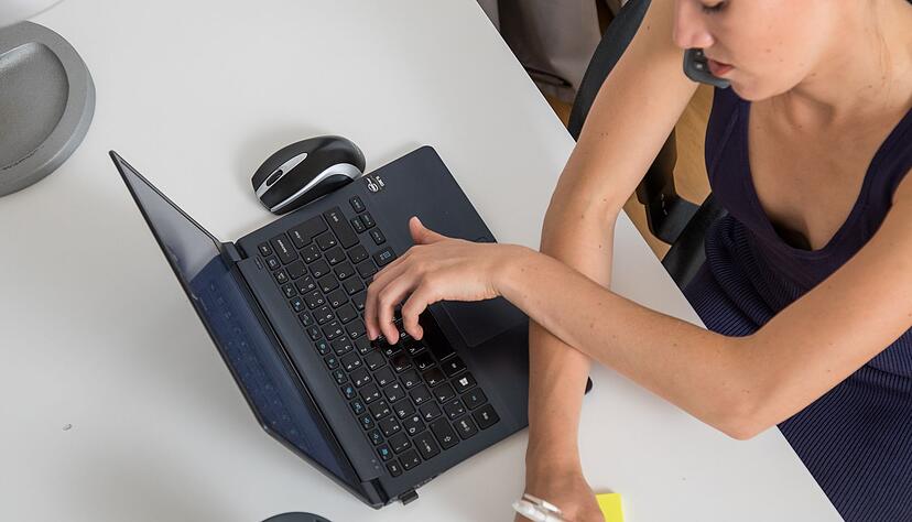 Eine negative Arbeitskultur verleitet dazu, Produktivit&auml;t vorzut&auml;uschen. Das zeigt sich etwa so, dass eine Kollegin telefoniert, gleichzeitig tippt und Notizen anfertigt.