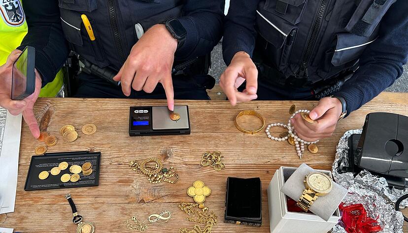 Die Zollbeamten wiegen den sichergestellten Goldschmuck.
