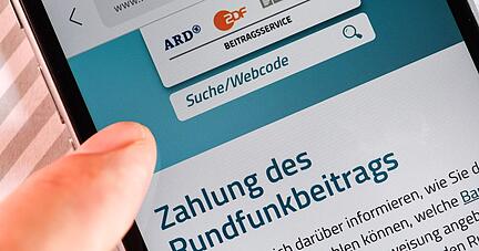 Auf einem Smartphone ist eine Website zur Information über die Zahlung des Rundfunkbeitrags aufgerufen.