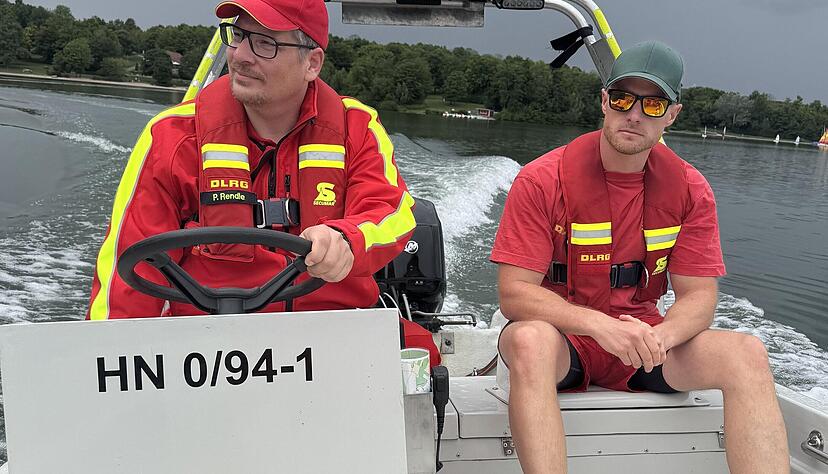 Es blitzt und donnert am Breitenauer See. Patrick Rendle (links) und Martin K.  warnen Schwimmer vor dem aufziehenden Gewitter.