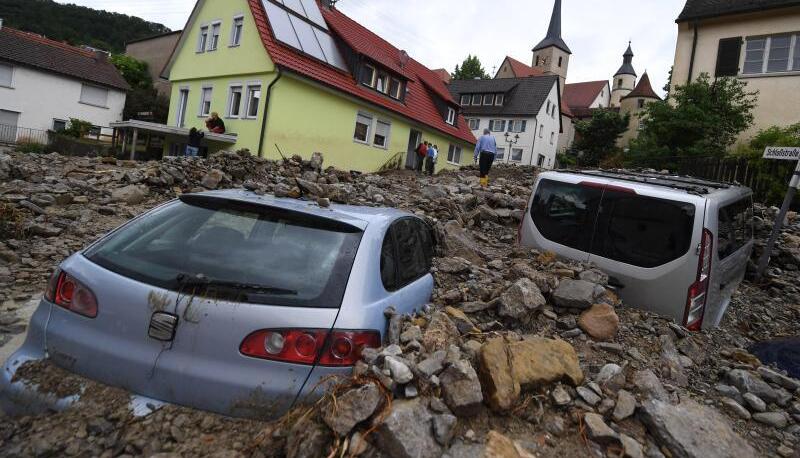 Autos liegen in Braunsbach unter einer Schutthalde. Ein Sturmtief hinterließ Ende Mai in einigen Regionen Baden-Württembergs verheerende Schäden. Foto: Marijan Murat/Archiv
