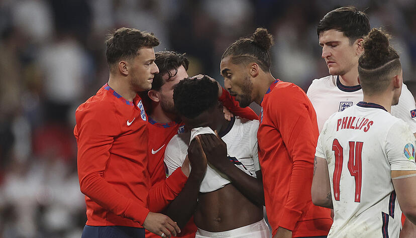 Nach seinem verschossenen Elfmeter wird Englands Bukayo Saka (Mitte) von seinen Mitspielern getröstet. Foto: dpa