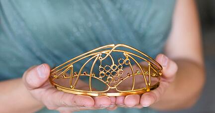 Eine Frau h&auml;lt die Krone einer Weink&ouml;nigin in den H&auml;nden.