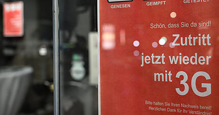 Ein Hinweisschild mit Zutrittsregeln hängt an der Tür eines Ladens in der Stuttgarter Innenstadt. Nach den neuen Regeln können Ungeimpfte wieder mit einem aktuellen Test shoppen gehen.