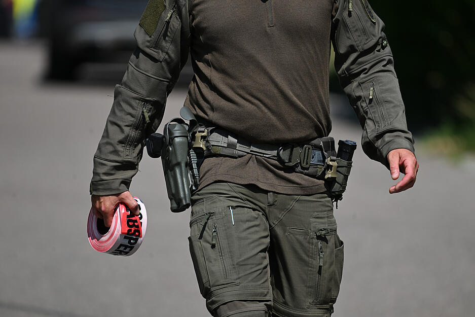 Ein Polizeibeamter hält eine Rolle mit Flatterband. Die Polizei ist in Rosengarten (Landkreis Schwäbisch Hall) zu einem größeren Einsatz ausgerückt. Ein Polizeibeamter hält eine Rolle mit Flatterband. Die Polizei ist in Rosengarten (Landkreis Schwäbisch Hall) zu einem größeren Einsatz ausgerückt.