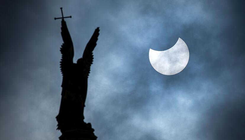 Eine partielle Sonnenfinsternis &uuml;ber der Statue des Erzengel Michael auf der Kuppel des Schweriner Schlosses.