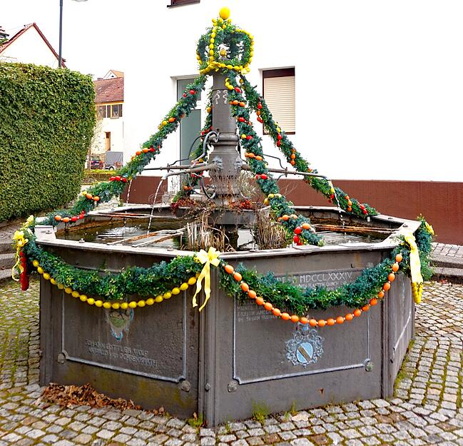 In Eberstadt schm&uuml;cken die Landfrauen seit vielen Jahren den Brunnen in der Hauptstra&szlig;e, der fr&uuml;her eine Viehtr&auml;nke war mit Buchs- und bunten Ostereier-Girlanden.