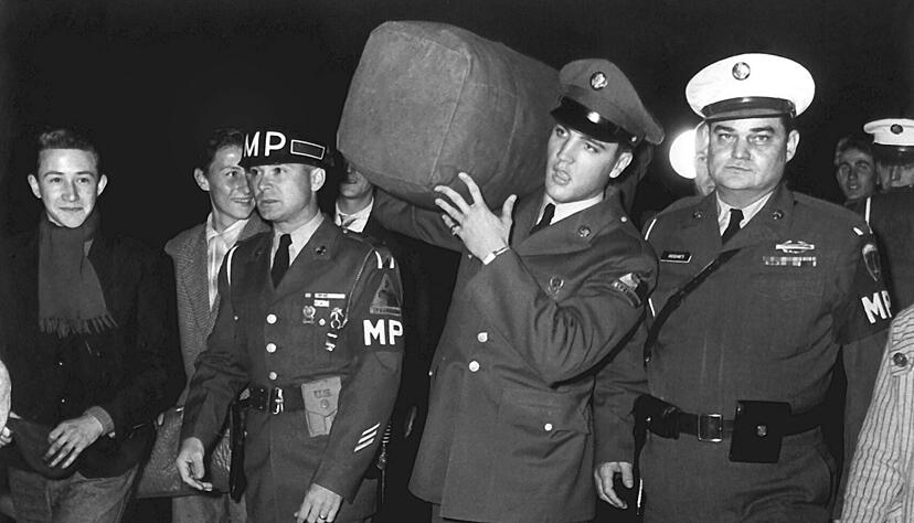 ARCHIV - Der US-amerikanische Rock 'n' Roll-Sänger Elvis Presley (M, mit Gepäck) war zur Freude seiner deutschen Fans von Oktober 1958 (Foto) bis März 1960 im Rahmen seines Militärdienstes in der US Army im hessischen Friedberg stationiert. ARCHIV - Der US-amerikanische Rock 'n' Roll-Sänger Elvis Presley (M, mit Gepäck) war zur Freude seiner deutschen Fans von Oktober 1958 (Foto) bis März 1960 im Rahmen seines Militärdienstes in der US Army im hessischen Friedberg stationiert.