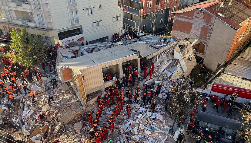 Feuerwehrleute und Rettungskr&auml;fte suchen nach dem Einsturz eines Wohngeb&auml;udes nach Versch&uuml;tteten.