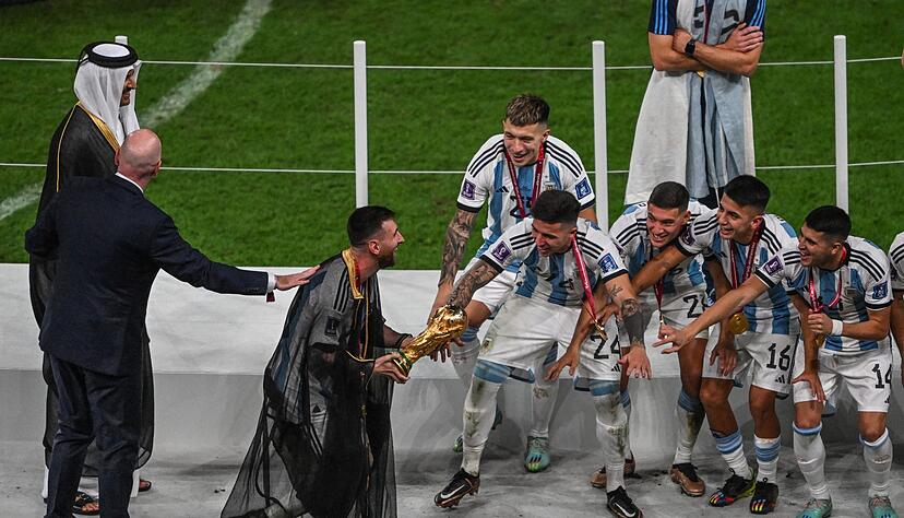 Lionel Messi mit dem WM-Pokal auf dem Weg zu seinen Mannschaftskollegen.