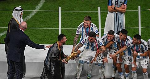 Lionel Messi mit dem WM-Pokal auf dem Weg zu seinen Mannschaftskollegen.