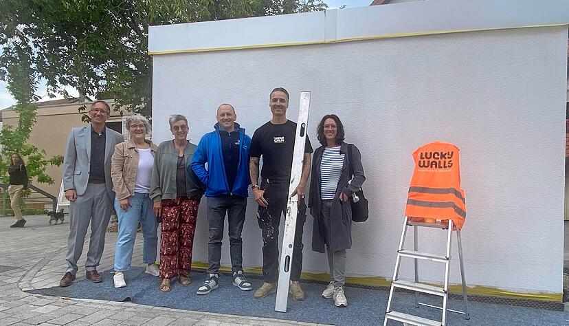 Noch ist die Wand weiß. Bis Mittwoch will Peter Stöcker (zweiter von rechts) sein Kunstwerk auf dem Trafohäuschen fertiggestellt haben.