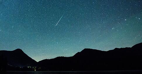 Eine Sternschnuppe leuchtet neben der Milchstraße am Himmel über dem Walchensee. Eine Sternschnuppe leuchtet neben der Milchstraße am Himmel über dem Walchensee.