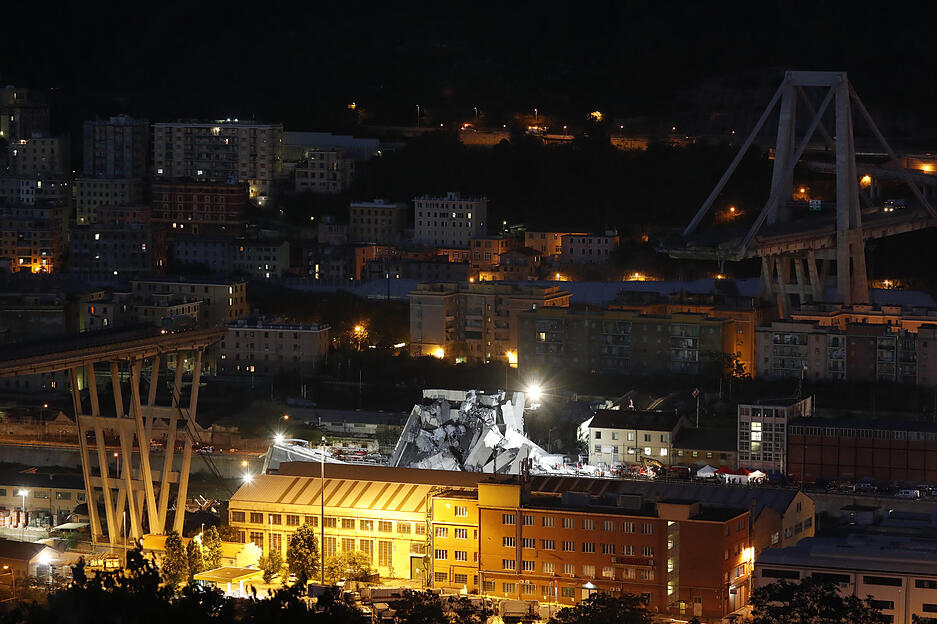 Rettungskr&auml;fte suchen nachts nach &Uuml;berlebenden w&auml;hrend Scheinwerfer den Bereich ausleuchten. Foto: dpa
