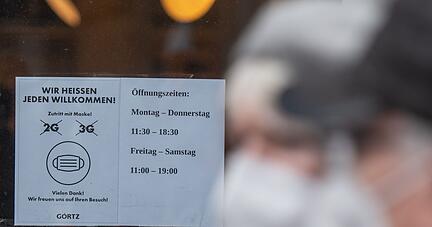 «Wir heißen jeden Willkommen» sowie 2G und 3G durchgestrichen hängt im Schaufenster eines Schuhgeschäftes in der Innenstadt von Dortmund.